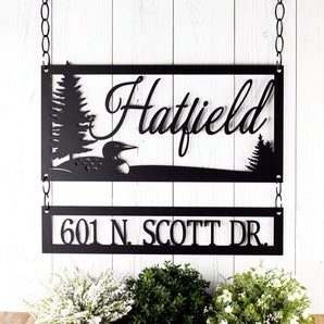 Hanging rectangular family name and address plaques, with a loon and lake scene, in matte black powder coat. 
