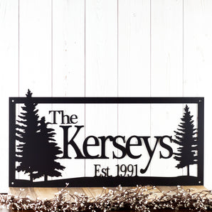 Rectangular family last name and established year metal sign with pine trees, in matte black powder coat.