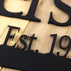 Close up of matte black powder coat on our family name and established year metal sign.