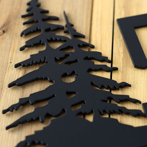 Close up of matte black powder coat on our 1 digit metal house number sign with pine trees.