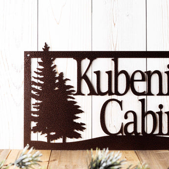 Close up of pine trees on our rectangular home name metal sign, in copper vein powder coat. 