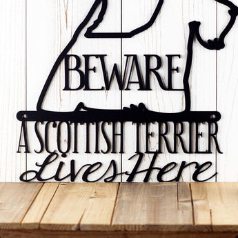 Close up of A Scottish Terrier Lives Here wording on our Scottish Terrier metal sign, with Beware, in matte black powder coat.