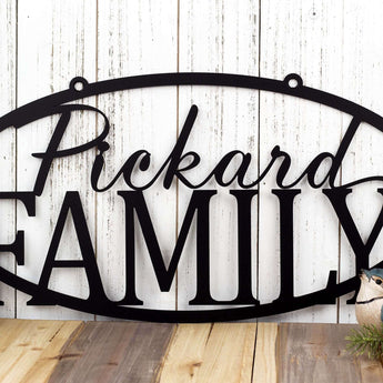 Personalized oval family name sign with a script font, in matte black powder coat. 