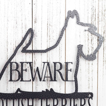 Close up of Scottish Terrier silhouette, with Beware, in silver vein powder coat.