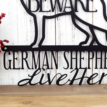 Close up of German Shepherds Live Here wording on our German Shepherd metal wall art, in matte black powder coat. 