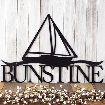 Family name metal sign with a sailboat silhouette, in matte black powder coat. 