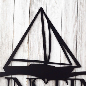 Close up of a sailboat on our personalized family name metal sign, in matte black powder coat. 