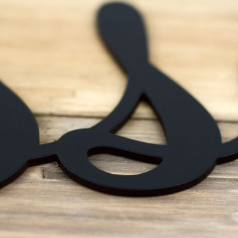 Close up of matte black powder coat on our Blessed script metal sign.