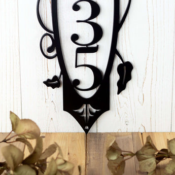 Close up of vines and fleur de lis on our 4 digit vertical metal house number sign, in matte black powder coat.