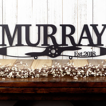 Close up of family name propeller metal sign for aviators, with an established year, in matte black powder coat. 