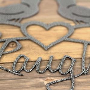 Close up of silver vein powder coat on our Live Laugh Love metal wall art with birds and heart.