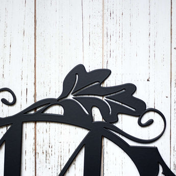 Close up of oak leaf on our 2 digit oval metal house number sign, in matte black powder coat.