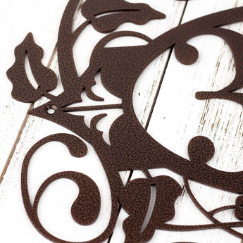 Close up of fleur de lis and vines on our metal house number sign, in copper vein powder coat.