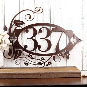 Personalized oval metal house number sign with fleur de lis and vines, in copper vein powder coat.