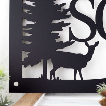 Close up of deer silhouette on the rectangular family name sign, in matte black powder coat.