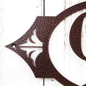 Close up of fleur de lis and mounting hole on our 2 digit metal house number sign, in copper vein powder coat. 