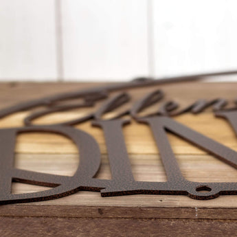 Close up of copper vein powder coat on the oval metal family name sign. 