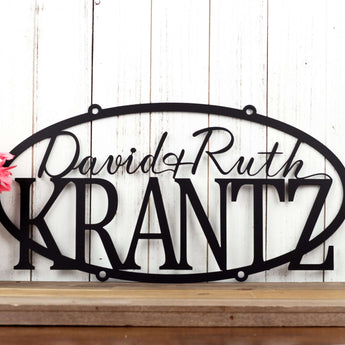 Oval family name metal plaque with first names and last name, in matte black powder coat.