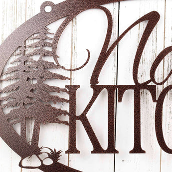 Close up of pine trees on our custom kitchen name plaque, in copper vein powder coat. 