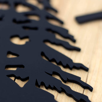 Close up of matte black powder coat on our 2 digit metal house number sign with pine trees. 