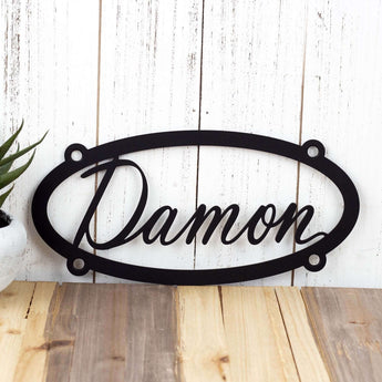 Personalized oval metal sign with child name, in matte black powder coat.