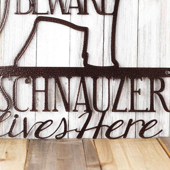 Close up of A Schnauzer Lives Here metal sign, in copper vein powder coat.