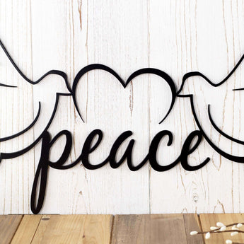 Close up of peace script lettering and heart on our peace dove metal sign, in matte black powder coat.