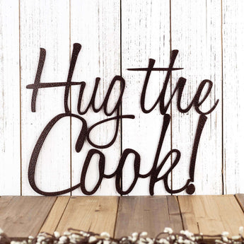 Close up of Hug the Cook! script metal sign, in copper vein powder coat.