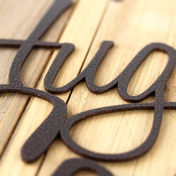 Close up of copper vein powder coat on our Hug the Cook! metal wall art.