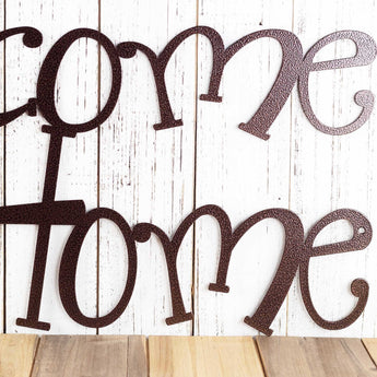 Close up of wording on our Welcome to our Home metal wall art, in copper vein powder coat.