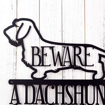Close up of Wire Haired Dachshund dog silhouette on our Dachshund Owns This Home metal sign, in matte black powder coat. 