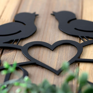 Close up of matte black powder coat on our Live Laugh Love metal sign with birds and heart.