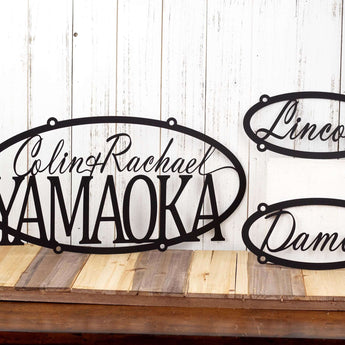 Custom oval metal sign with first and last name, and two child name signs, in matte black powder coat.