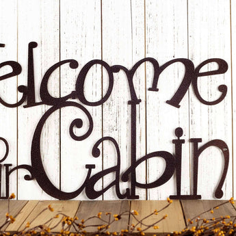 Close up of Welcome to our Cabin metal wall decor, in copper vein powder coat.