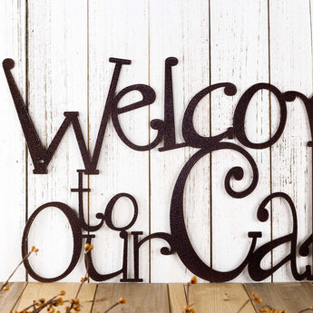 Close up of Welcome to our Cabin metal sign, in copper vein powder coat.