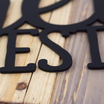 Close up of matte black powder coat on our family name and established metal sign.