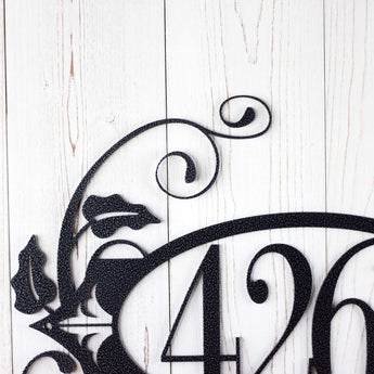 Close up of vines and fleur de lis on our 4 digit metal house number sign, in silver vein powder coat.