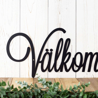 Close up of script lettering on our Välkommen metal wall art, in matte black powder coat.