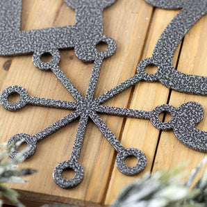 Close up of silver vein powder coat on our Let it Snow metal wall art.