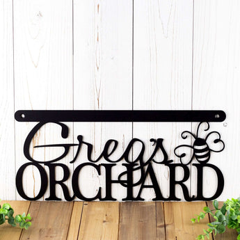 Close up of hanging orchard metal sign with first name and dragonfly, in matte black powder coat.