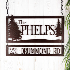 Personalized rectangular family name and address metal signs with pine trees, in copper vein powder coat.