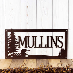 Rectangular metal family last name sign with loon and pine trees, in copper vein powder coat.
