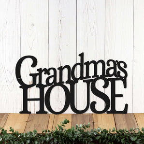 Grandma's House metal word wall art, in matte black powder coat. Placed against a white wood wall.