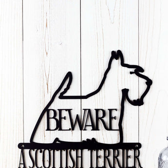 Close up of Scottish Terrier dog silhouette, with Beware, on A Scottish Terrier Lives Here metal sign, in matte black powder coat.