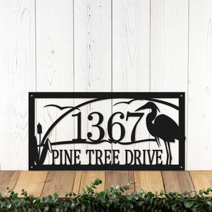 Rectangular metal address sign with great blue heron, cattails, and and sunset lake scene, in matte black powder coat.