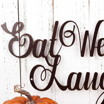 Close up of Eat Well Laugh Often Love Much script metal sign, in copper vein powder coat.