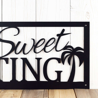 Close up of palm trees on our family name metal sign, in matte black powder coat.
