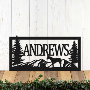 Rectangular metal family name sign with horse, mountains, and pine trees, in matte black powder coat.