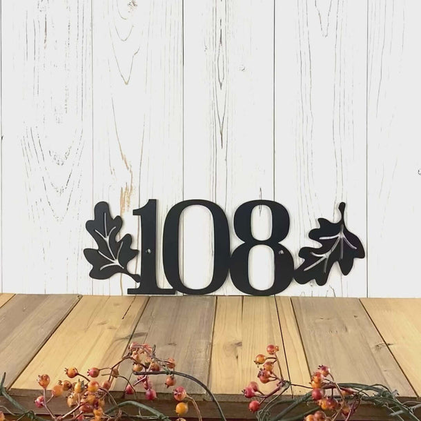 Video of horizontal metal house number sign with autumn oak leaves, in matte black powder coat.