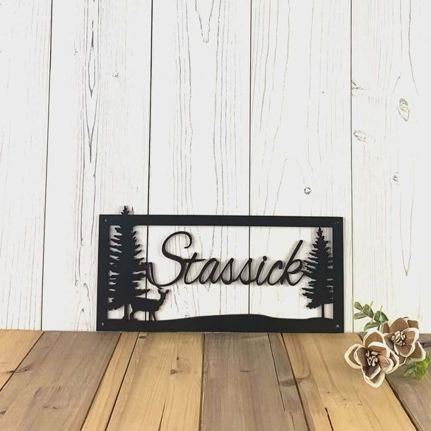 Video of script family name metal sign with doe deer and pine trees, in matte black powder coat.